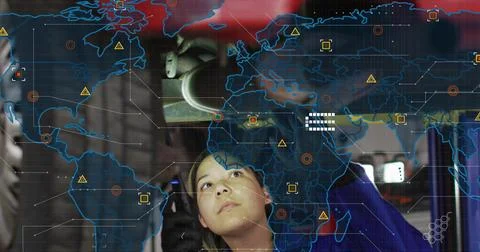 Female tech inspecting overhead component in bay as system sending AR world map Stock Photos