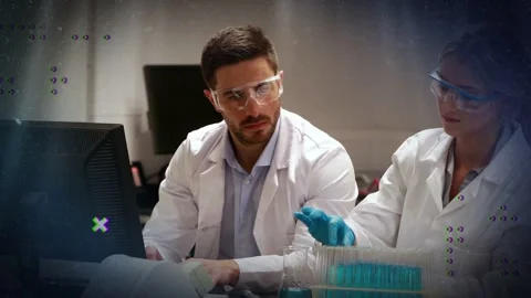 Female tech raising test tube, male tech watching screen, animated overlays Stock Footage 333301351
