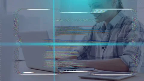 Female tech worker typing on laptop at desk, initiating HUD code animation and Stock Footage 335739232