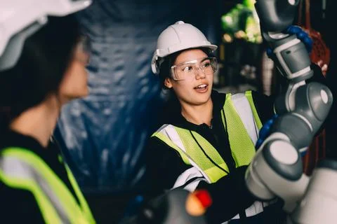 Female technician engineer using controller checking robotic machine Stock Photos
