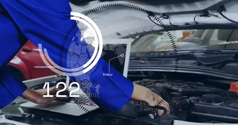 Female technician leaning over engine bay, typing on laptop and activating HUD Stock Footage 321783498