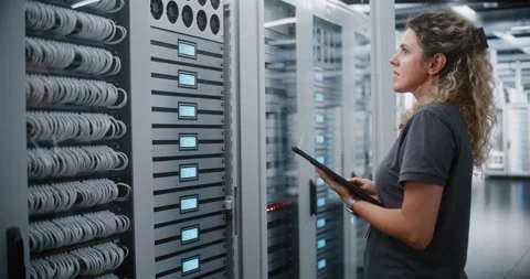 Female Technician Operating Server Cabinet Controls While Checking Tablet Data Stock Footage 344955888