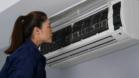 Female technician service open the air conditioner indoor for checking Video stock 155345053