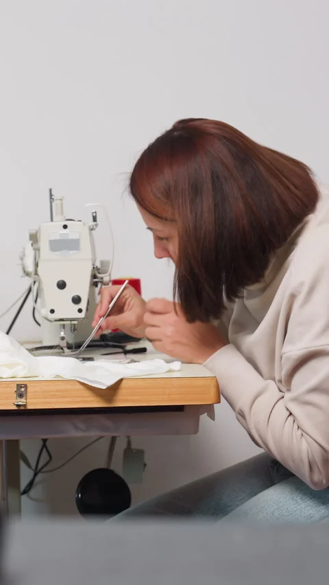 Female technician servicing sewing machine attentively, Skilled woman carefully Stock Footage 329513478