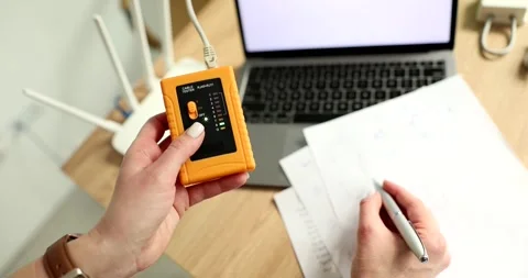 Female technician tests Internet cable of computer with tester Stock Footage 308881383