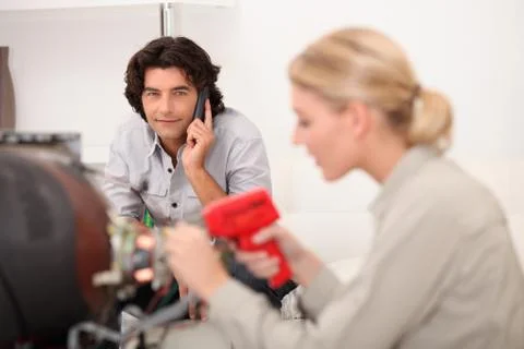 Female technician working while the client is talking on the phone Stock Photos
