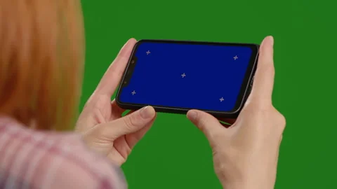 Female testing new application on blue screen horizontal phone in a green Stock Footage 299654167