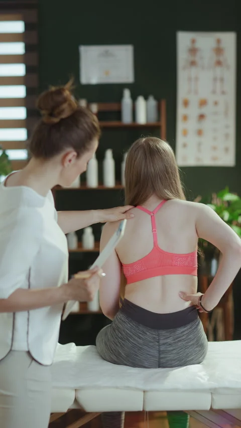 Female therapist checking back condition during examination Stock Footage 286064215