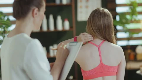Female therapist checking neck condition during examination Stock Footage 282677680
