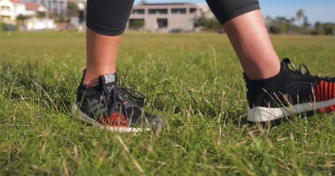 Female ties sneakers before doing exercise in a park Stock Footage 138253484