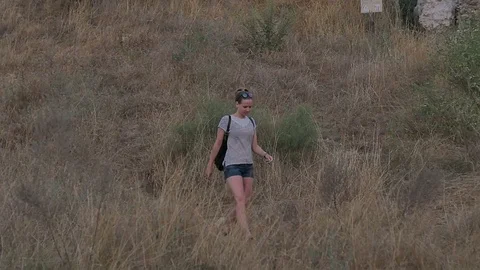 Female tourist with backpack exploring the ancient area Видео 76925487