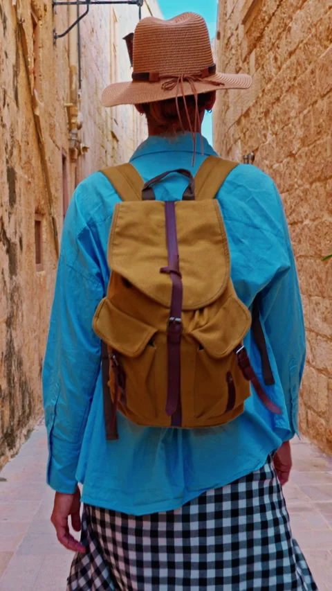 A female tourist in a hat and with a backpack walks along the traditional Stock Footage 342969426