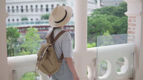 Female tourist in hat with backpack is walking along galleria 動画素材 341112361