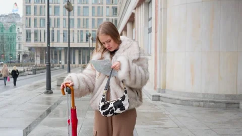 A female tourist navigating with a map while walking in Warsaw, Poland Stock Footage 311001407