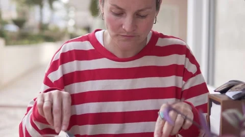 A female tourist in a striped jacket eats a cake on the street in a restaurant Stock Footage 235335420