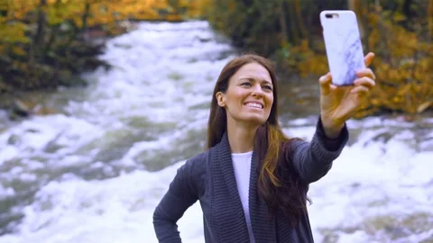 Female tourist taking selfie in woods during fall autumn season Stock Footage