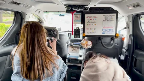 Female Tourist Using Digital Camera Inside a Tokyo Taxi Van Stock Footage 331408872
