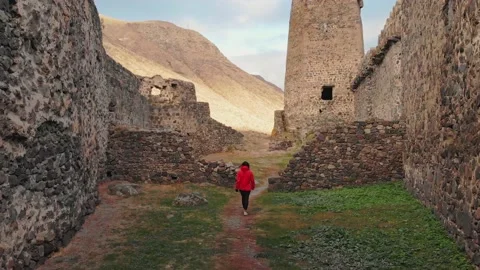 Female tourist walks down the path surrounded by Khertvisi fortress wall ruin Vídeos de archivo 146446997