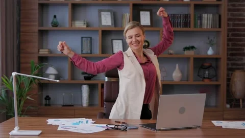Female trader dancing at workplace. Happy businesswoman got positive news Stock Footage 244646972