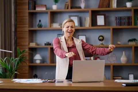 Female trader dancing at workplace. Happy businesswoman got positive news Stock Photos