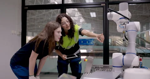 Female trainee reacting with excitement while observing robotic arm operation Stock Footage 326577589