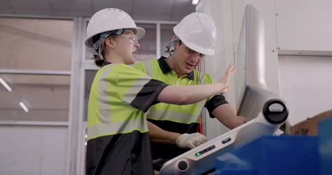 Female trainee working with male instructor on CNC machine programming during Stock Footage 313649688