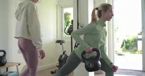 Female trainer and client stepping in correcting form and guiding kettlebell Stock Footage 339320721