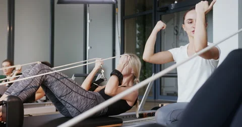 Female trainer explaining pilates exercise to group. Female coach gesticulating Stock Footage 148564334
