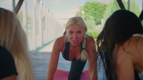A female trainer explains the exercise to her students, Two girls listen to the Stock Footage 137024415