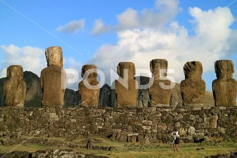 Photograph: Female traveler photographing the back of Moai statues at ...