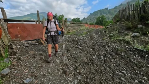 Female trekker hikes, front view, along a rural path Stock Footage 343774490