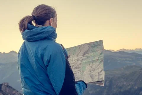 Female trekker studying a map. Stock Photos