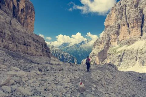Female trekker walking along mountain valley. Stock Photos