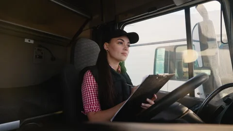 Female truck driver checking documents inside cabin Video stock 299754722