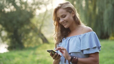 Female typing message on smartphone and smile Stock Footage 93660140