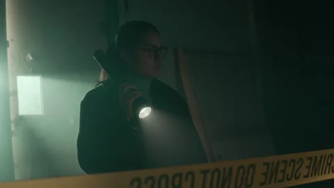 Female Undercover Agent Looking Around with Flashlight at Crime Scene 库存影片 300190253