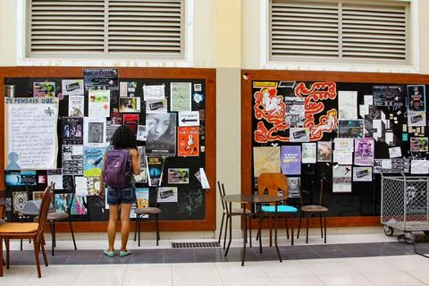 Female University Student looking at posters in he University Lobby Lounge Stock Photos