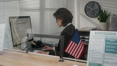 Female US Consulate Visa Agent Working on Computer behind Counter Stock Footage 331506559