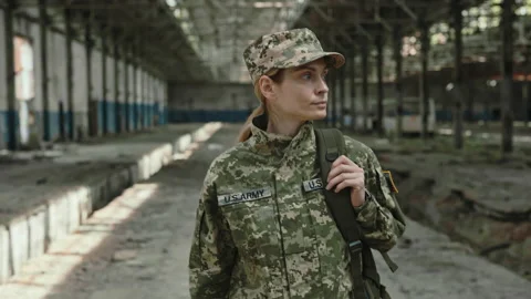 Female US soldier with backpack walking on ruined factory Stock Footage 198353064