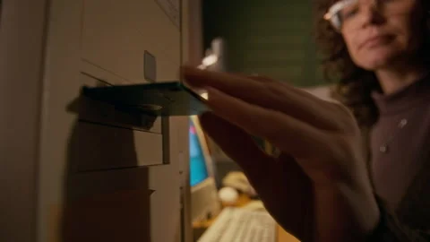 Female User Inserting Floppy Disk into Drive on Retro Computer Stock Footage 327239813