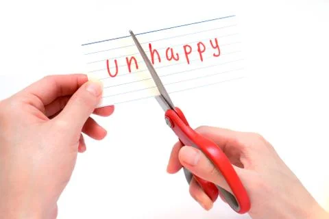 Female using scissors to remove the word unhappy to read happy concept for se Stock Photos