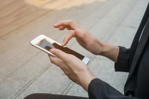Female using smartphone, focus on hands. Stock Photos
