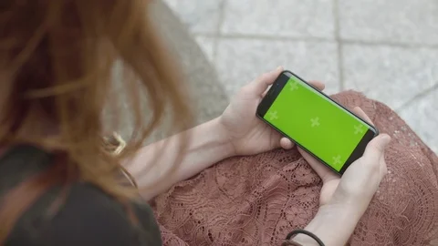 Female using smartphone with Green Mock-up Screen Sitting on bench in Business Video stock 111928362