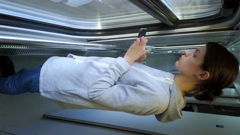 Female using smartphone. Standing in a train car near window. Vertical screen  Stock-Footage 125138248