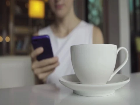 Female using smartphone while drinking coffee Video stock 81484547