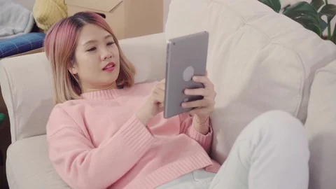 Female using tablet after moving home in living room at home. Stock Footage 104551693