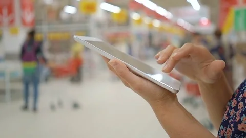 Female using tablet computer at supermarket hands close-up. Stock Footage 76860543