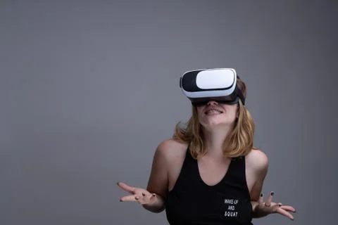 Female using VR gear is having fun and displaying a don't know attitude Stock Photos