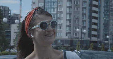 Female using  wireless earphones for conversation  outdoor. Modern technologies. Видео 126781027