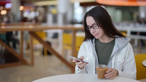 Female visitor of coffee shop is using smartphone for communicating in internet Stock Footage 169561779
